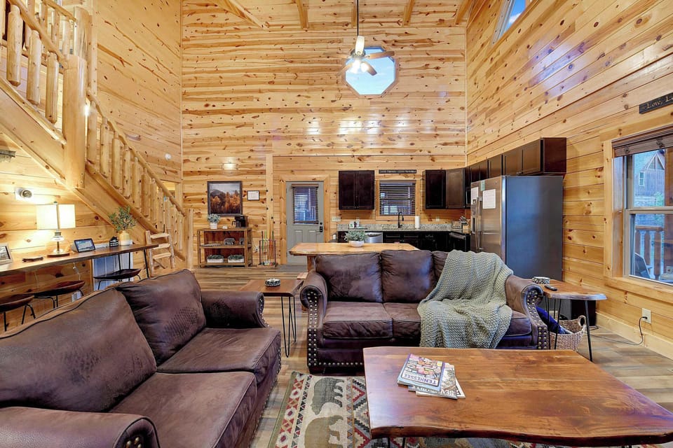Spacious rustic living area with vaulted ceilings and a fully equipped kitchen.