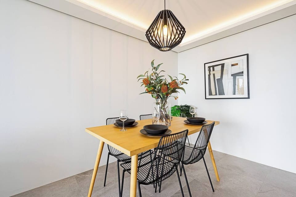 The open kitchen and dining area features a four-seater table setting with views to the river.