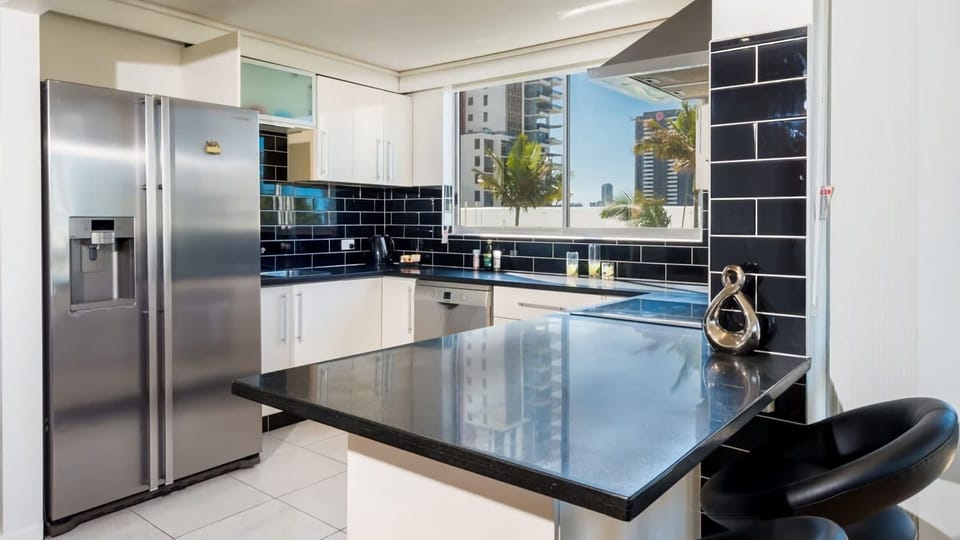 Kitchen area"Gourmet convenience meets sleek design: enjoy a full-sized fridge with water dispenser, dishwasher, and ample prep space for your holiday meals.