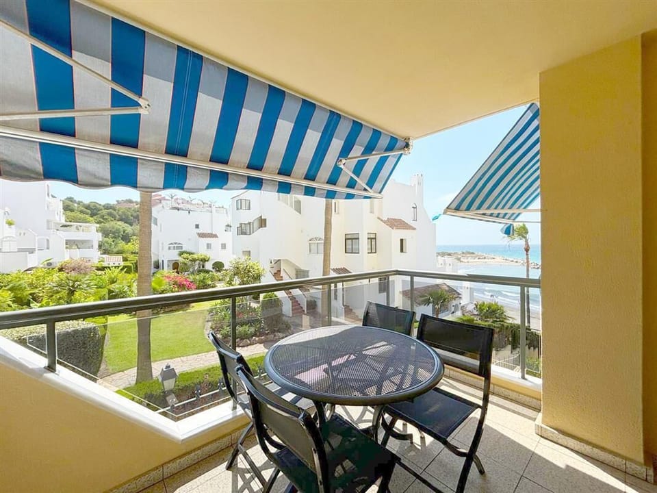 Sunny private terrace with sea views and dining area for four guests