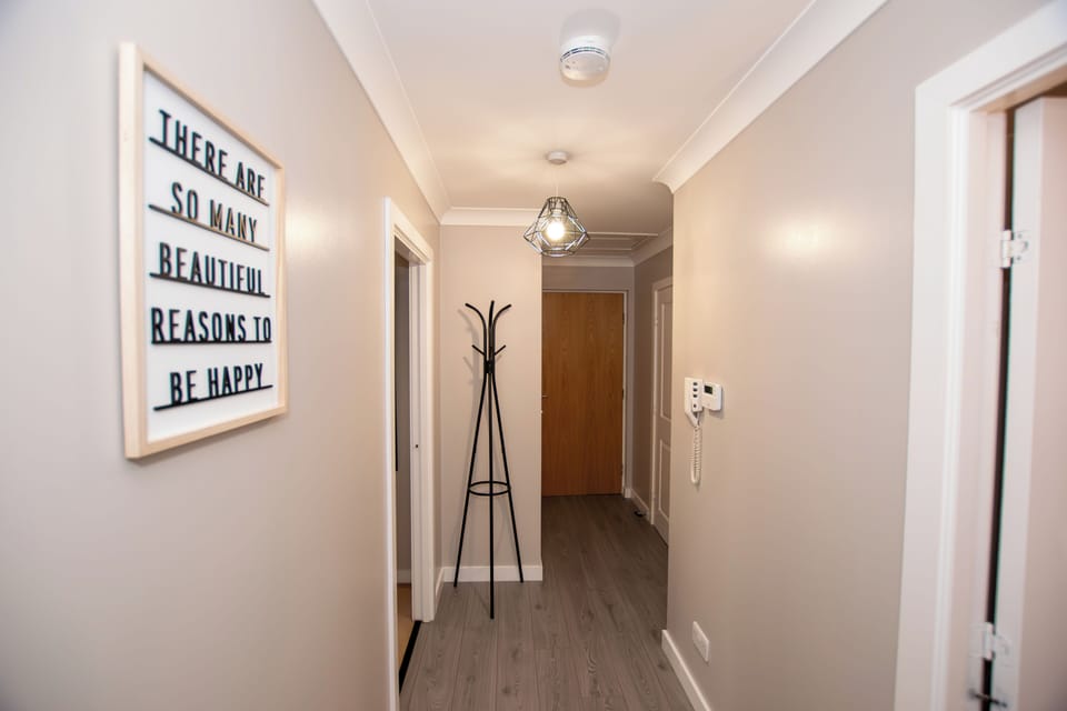 Bright and modern hallway with a convenient coat stand, offering a stylish first impression of this 
