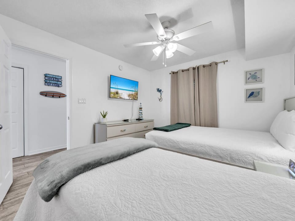 Drift off to sleep in your peaceful bedroom, where beach-themed décor and a gentle ceiling fan create the perfect coastal retreat for restful nights.