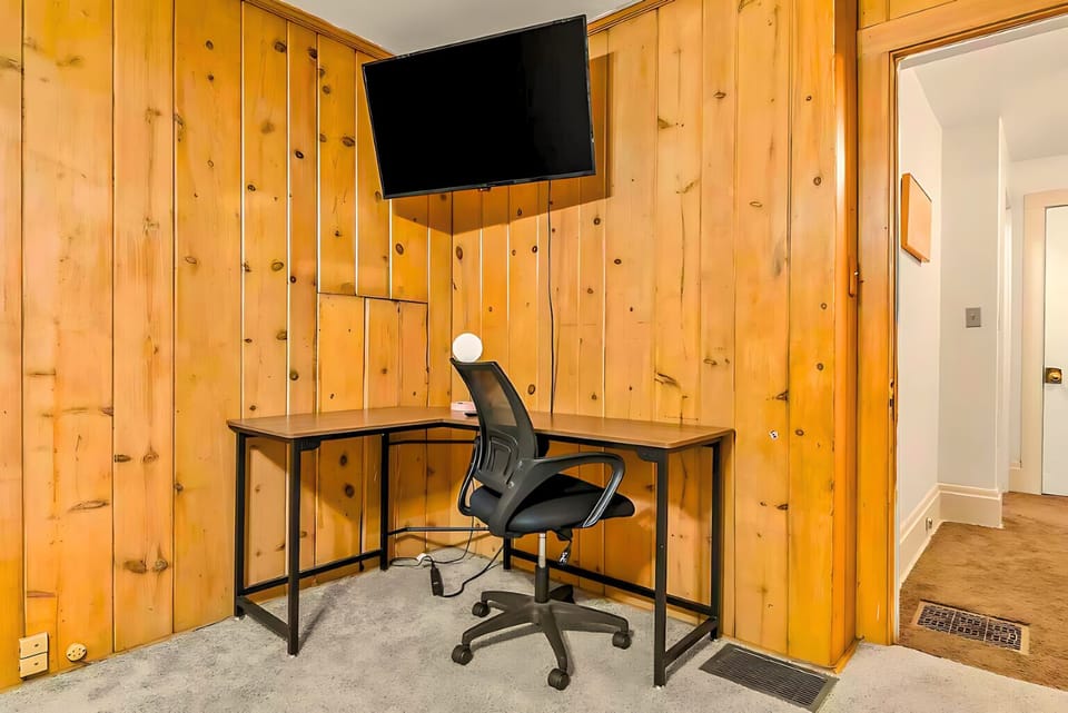 A rustic wood-paneled room, with a dedicated workspace ideal for productivity