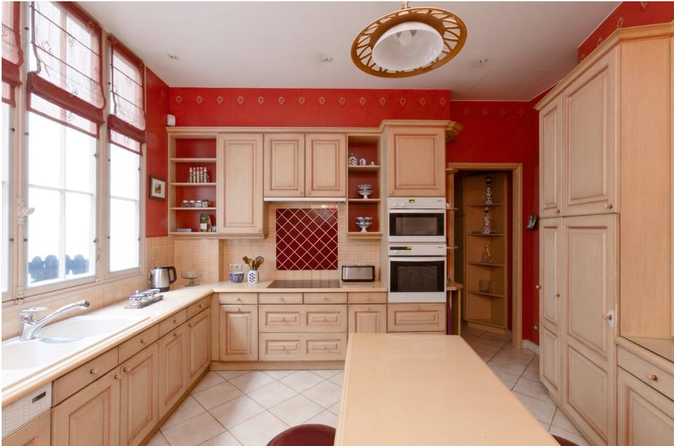 Kitchen is traditionally laid out with blonde wooden cabinets,latest appliances