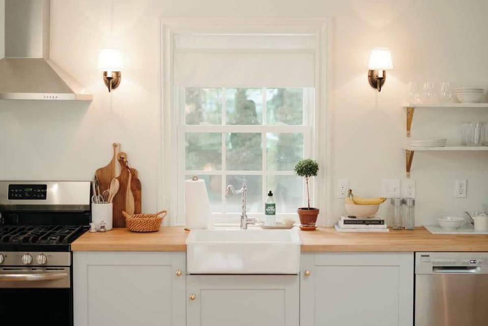This light-filled kitchen offers everyday essentials including a microwave, full stove, and coffee setup, all framed by classic design details