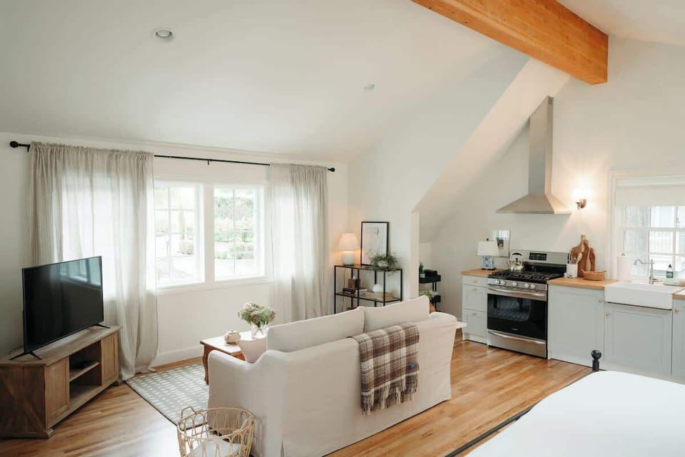 Living area with vaulted ceilings, full kitchen, and a cozy seating area with Smart TV for streaming.
