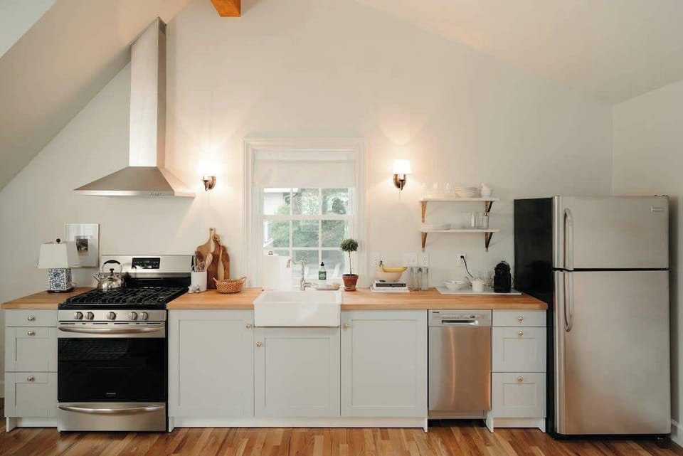 Well-equipped kitchen with gas range, farmhouse sink, and full-size fridge.