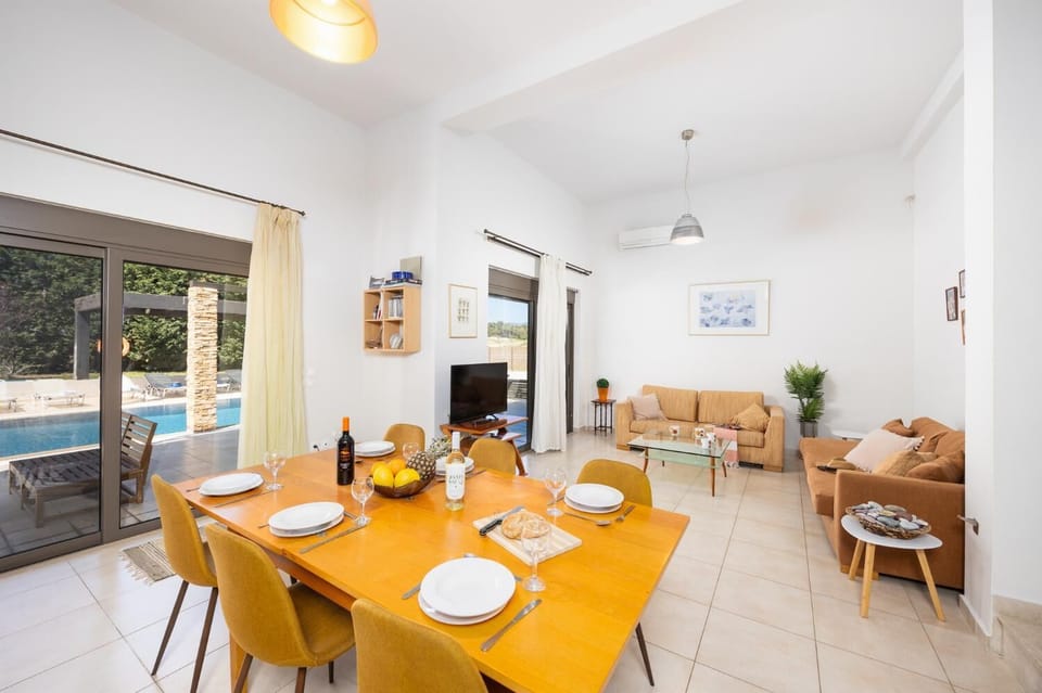 Main unit: open-plan living room with sofas, dining area, kitchen, A/C, WiFi internet, and satellite TV