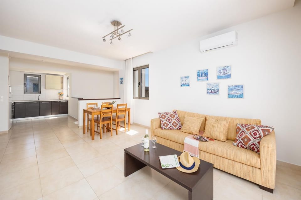 Upstairs unit: open-plan living room with sofa, dining area, kitchen, A/C, WiFi internet, and satellite TV