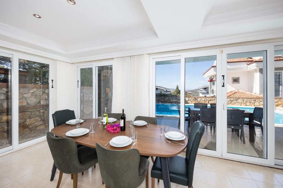 Open-plan living room with sofas, dining area, kitchen, ornamental fireplace, A/C, WiFi internet, and satellite TV