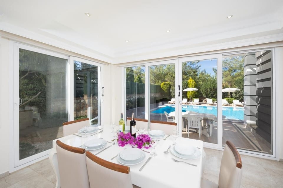Open-plan living room with sofas, dining area, kitchen, A/C, WiFi internet, and satellite TV
