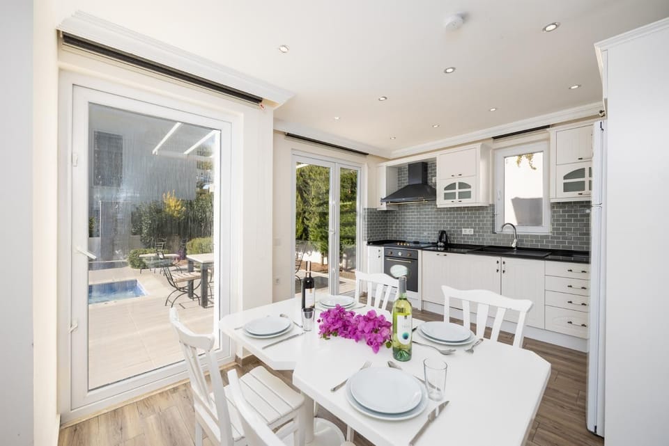 Open-plan living room with sofa, dining area, kitchen, A/C, WiFi internet, and satellite TV