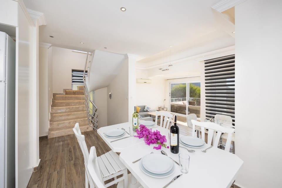 Open-plan living room with sofa, dining area, kitchen, A/C, WiFi internet, and satellite TV