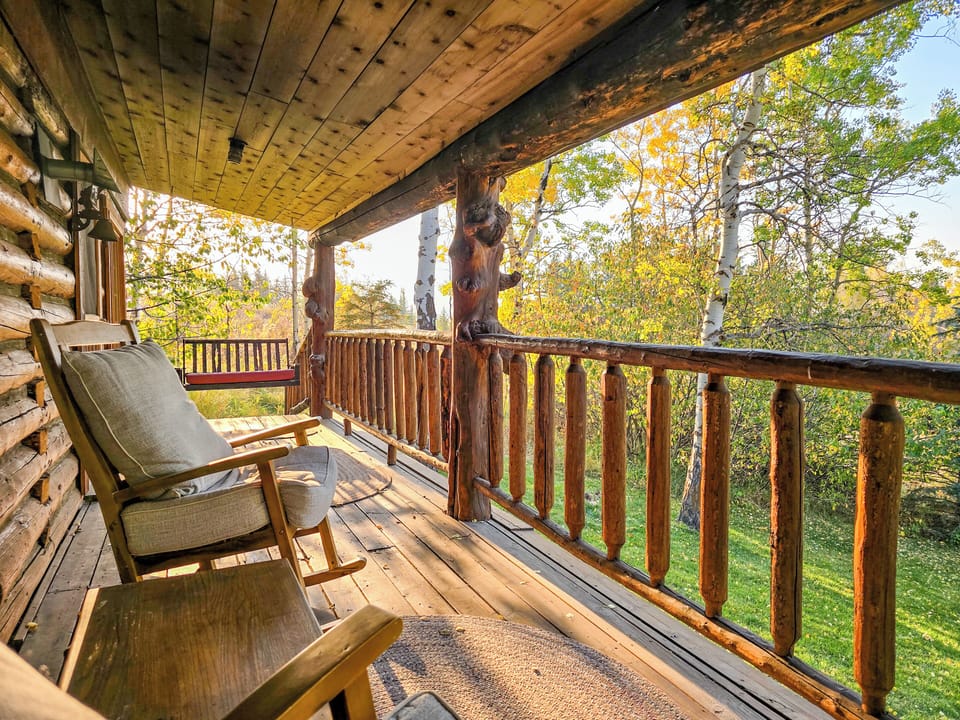 Cozy front porch with views of Henry's Lake and Sawtelle Mountain. Grab your favorite beverage and watch the animals or admire the sunset over the lake. Guests often see deer in the front yard! You'll love the view. 