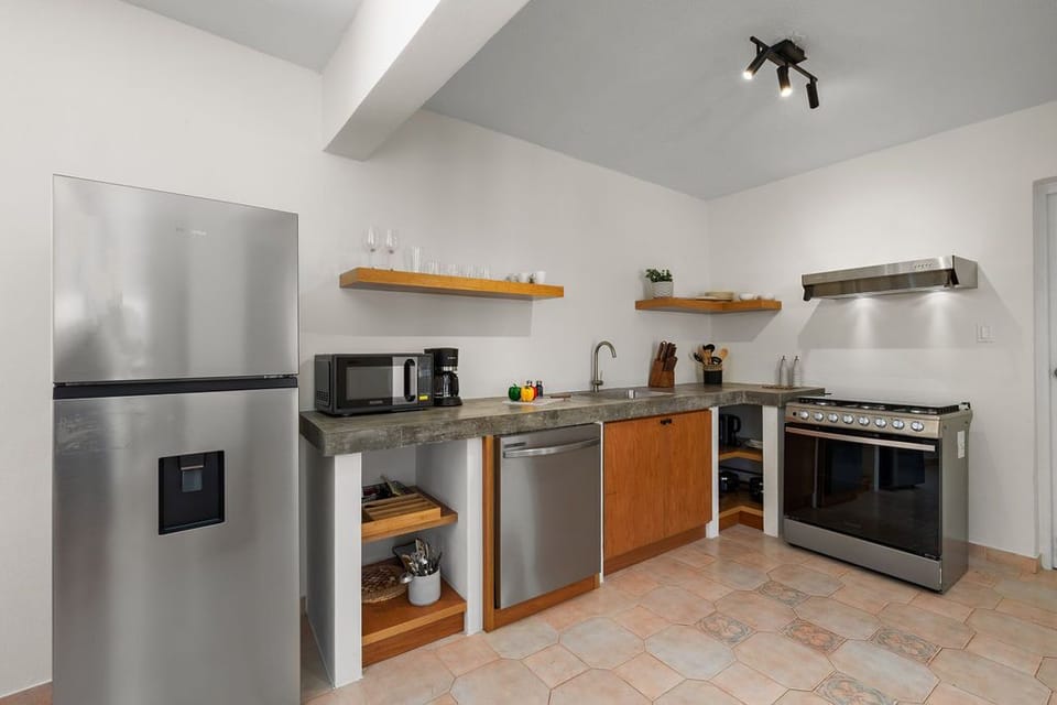 Equipped with modern appliances, including a refrigerator, stove, oven, and microwave, this kitchen allows you to prepare anything from quick snacks to gourmet meals.