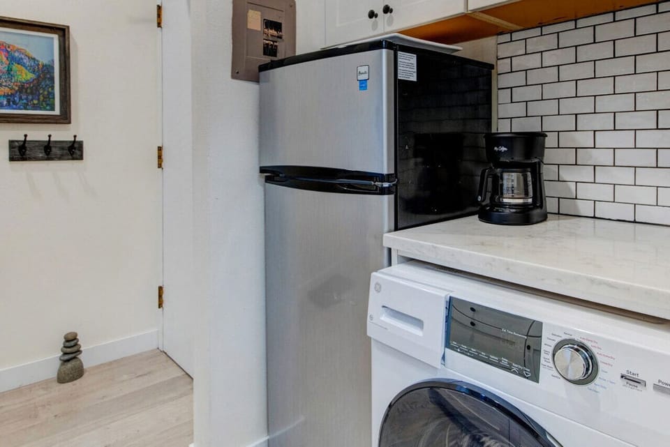 Your fully equipped kitchen features a modern stainless-steel fridge, coffee maker, and in-unit washer for ultimate convenience. Everything you need to feel right at home!
