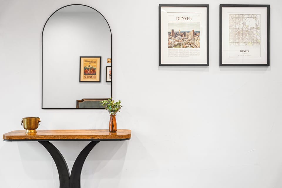 Your entryway welcomes you with thoughtful details—fresh florals on a handcrafted console table, a vintage accent piece, and curated Denver artwork that anchors you in this vibrant city.