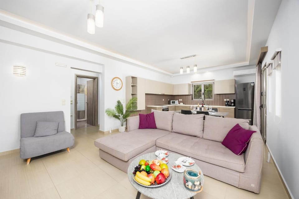 Open-plan living room with sofa, dining area, kitchen, A/C, WiFi internet, and satellite TV