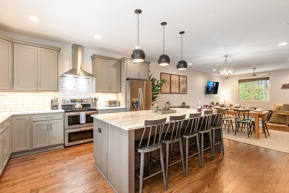 1st Floor: The fully equipped modern kitchen features culinary essentials, stainless steel appliances, and island bar seating.