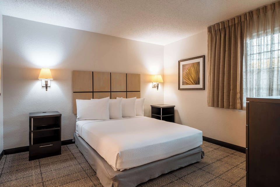 Unwind in a crisp, quiet bedroom with warm lighting.