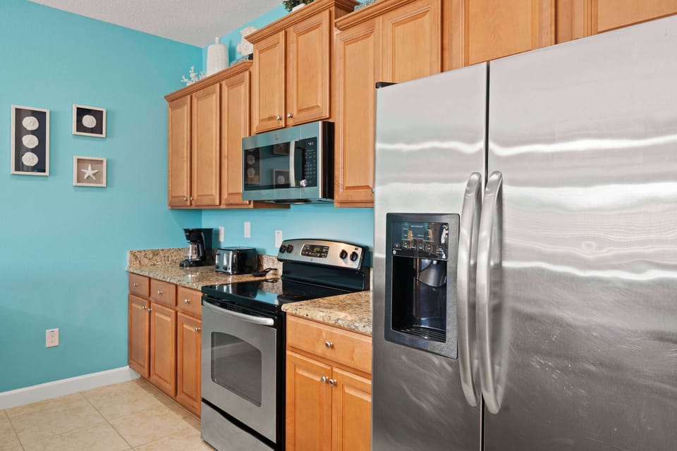 Cook and connect in a fully equipped kitchen featuring ocean-inspired details, modern appliances, and plenty of space for family gatherings.