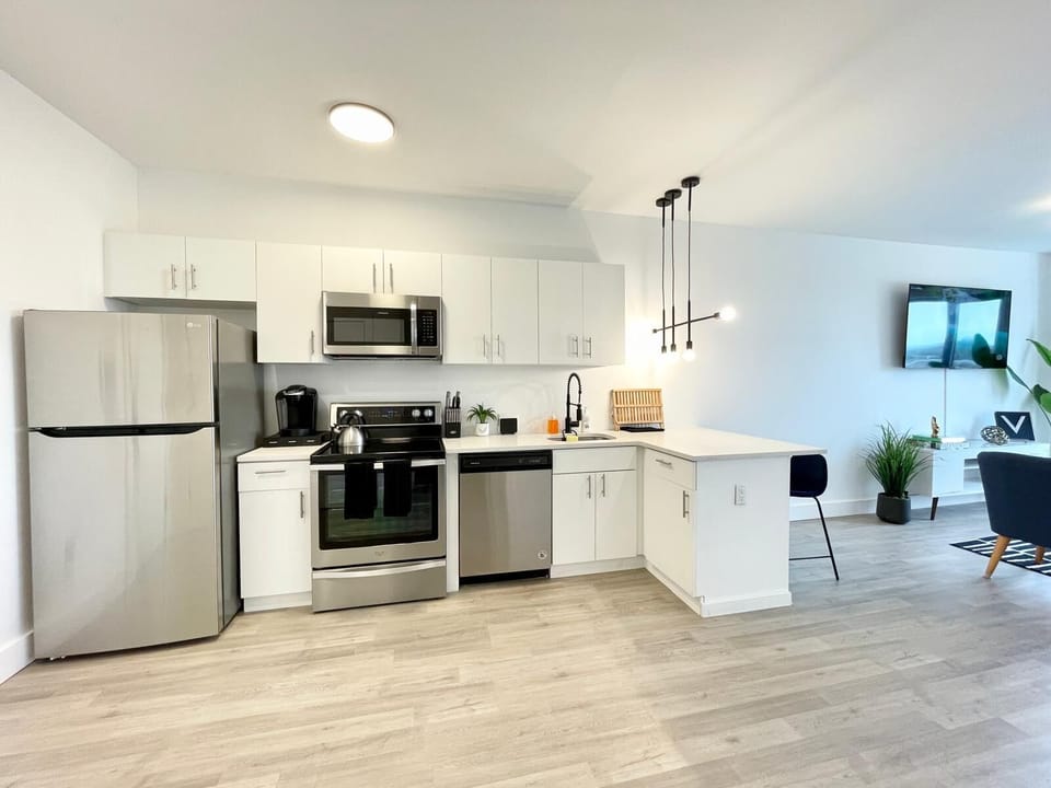 Open-concept kitchen with dining area, breakfast bar, and essential cookware.