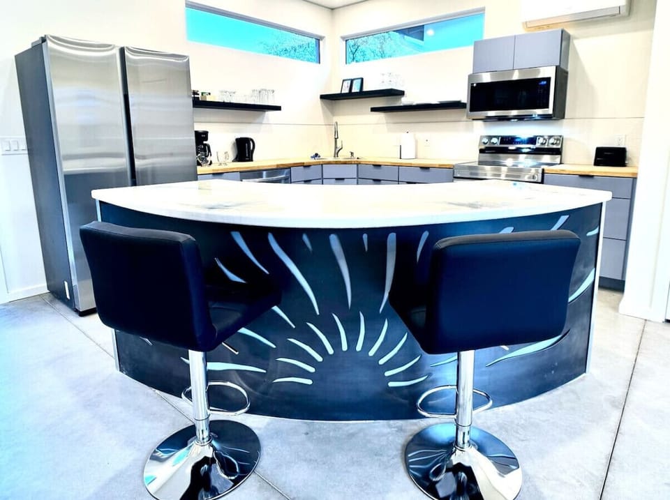 The wraparound kitchen Island has a custom cut metal feature.