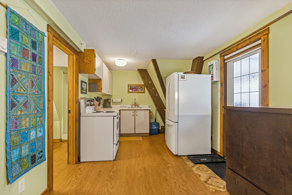 Kitchen is located to the left side of the Hide A Bed. Door next to the fridge leads outside to the patio area.