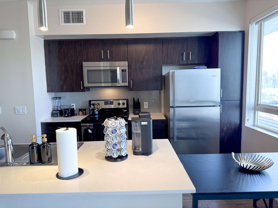 A fully equipped kitchen tailored for extended stays, complete with a sink and complimentary essentials like paper towels, dishwashing liquid, and handwash.