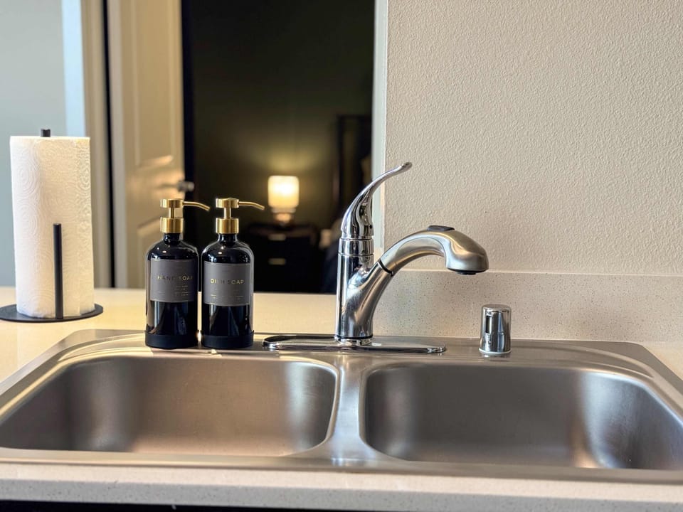 A fully equipped kitchen tailored for extended stays, complete with a sink and complimentary essentials like paper towels, dishwashing liquid, and handwash.