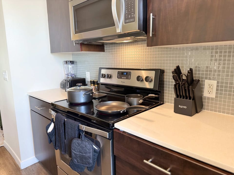 A fully equipped kitchen tailored for extended stays, complete with a sink and complimentary essentials like paper towels, dishwashing liquid, and handwash.