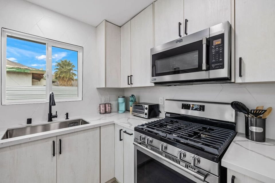 Modern kitchen w/ gas range, stainless appliances & clean white cabinetry for easy, everyday cooking.