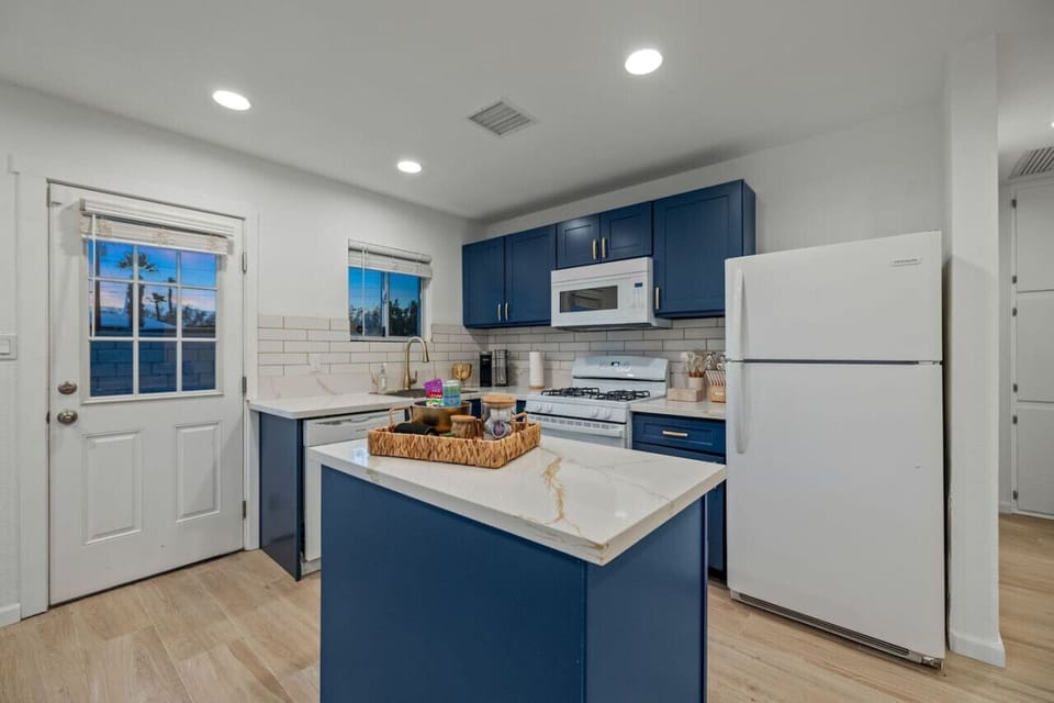 Modern kitchen w/ blue cabinetry and stainless appliances, ready for easy meals at home.