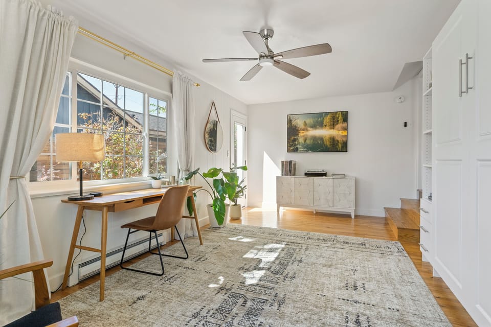 The den, a few steps down from the kitchen, offers a large space for multiple activities, and has a desk for those who need to work. The den can be closed off with french doors that separate it from the dining area.