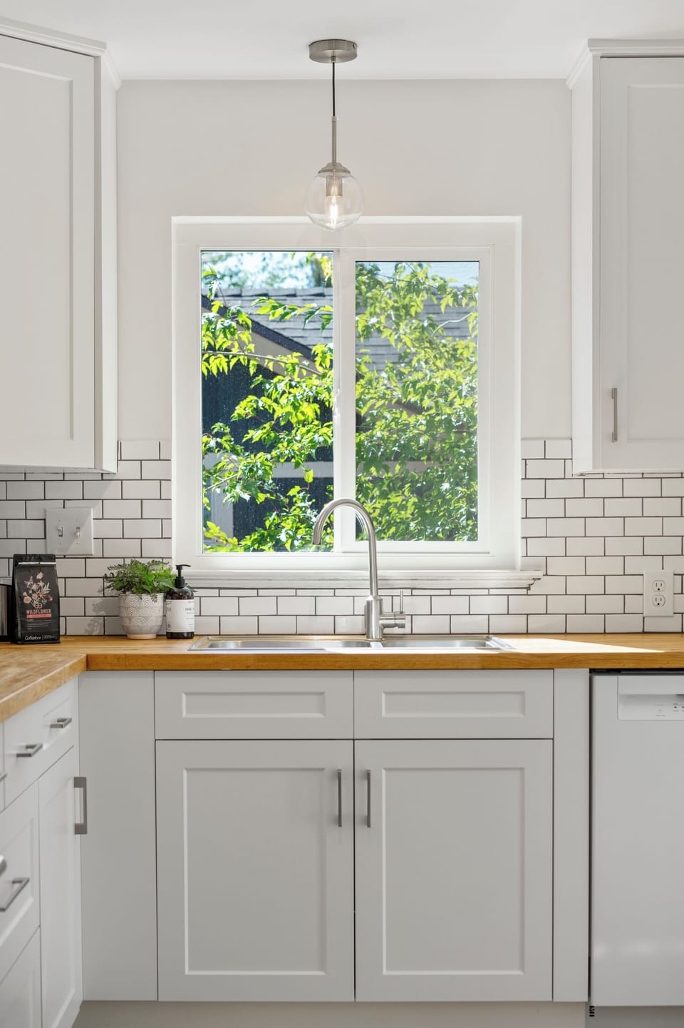 The kitchen, connected to the dining area, offers updated appliances including a stove, fridge, and dishwasher. The kitchen is well stocked with cooking and baking tools and appliances to allow guests in making meals as they would at home.