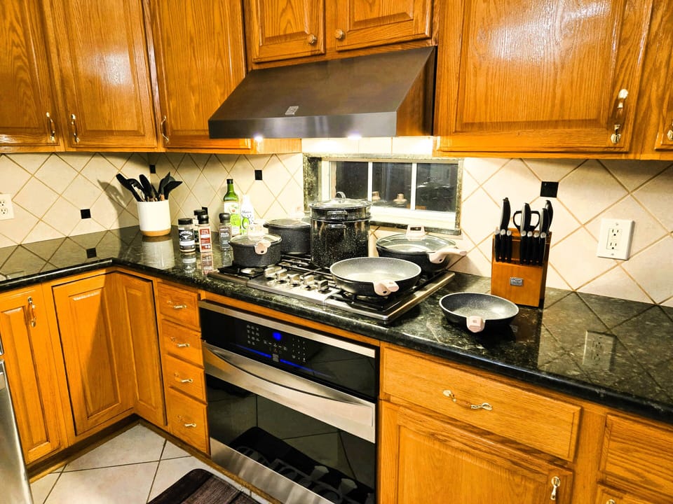 Modern kitchen, gourmet stove, oven, oils, knives, utensils at your exposal.

