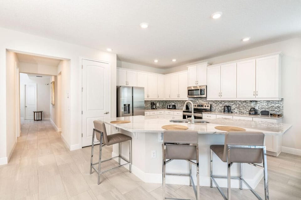 Spacious kitchen with modern appliances and breakfast bar seating up to 3 people