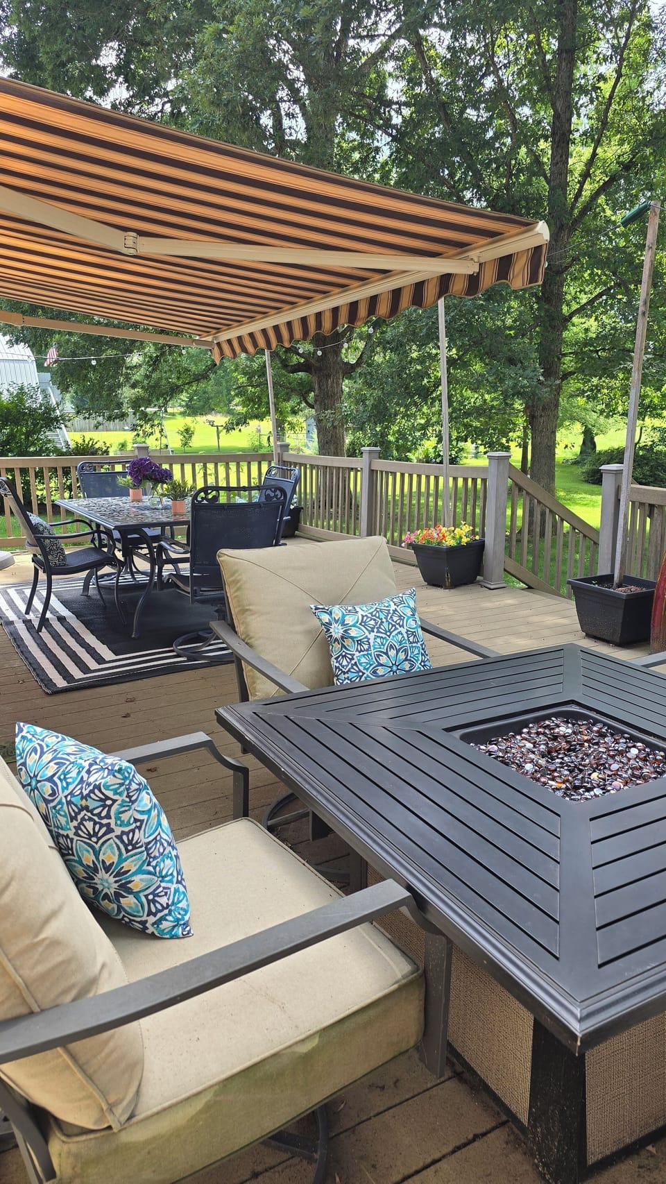 Large deck area with patio lights, grill, fire pit