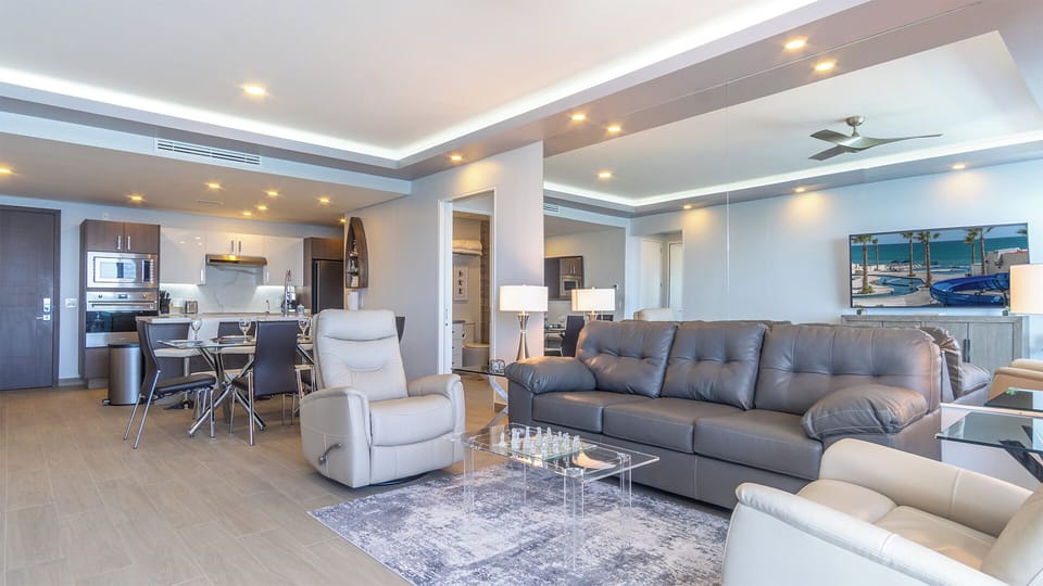 The unit is spacious, and you will find a dining table, the kitchen, and the living room against a mirrored wall shows city lights at night along with the amazing sun sets.