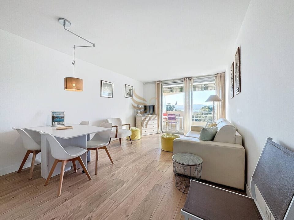 Séjour lumineux avec espace repas et accès balcon offrant une belle vue dégagée, parfait pour profiter des repas en toute sérénité.