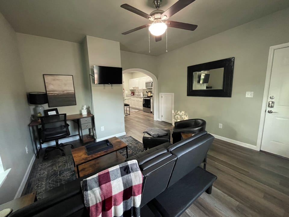 Living room with study area, tv, and fold out sofa bed.