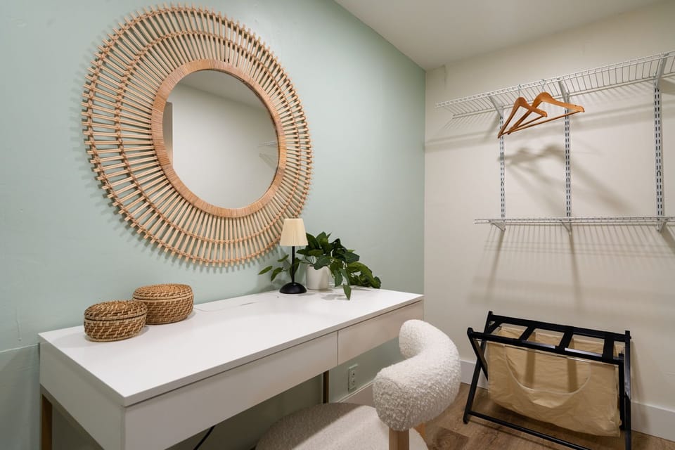 Stylish rattan mirror, basket, and table setup paired with ClosetMaid shelving.