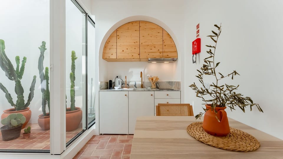 Prepare delicious meals in a chic kitchenette featuring marble countertops and warm wood accents. #MinimalistKitchen #HomeCooking