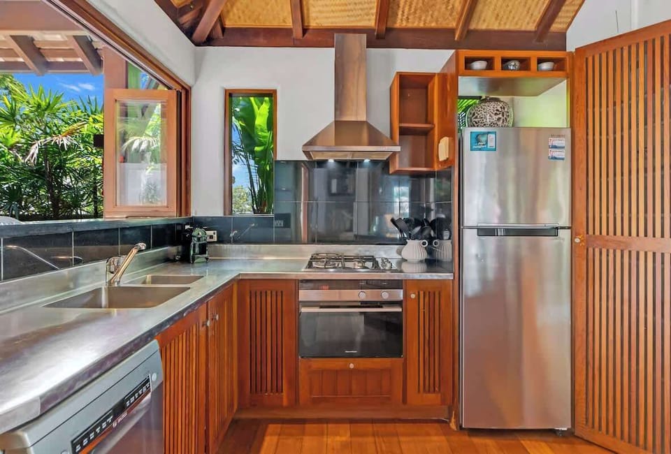 The kitchen is fully equipped for preparing meals at home and offers a convenient setting to easily serve both the dining area and deck for outdoor meals.
