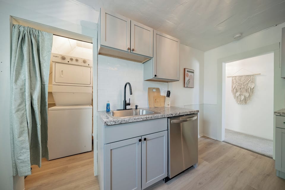 - Sleek kitchen design with stainless dishwasher and smooth stone style counters   - Functional layout offers storage modern cabinets and easy access laundry area   - Perfect for guests wanting a tidy updated space with everyday essentials ready