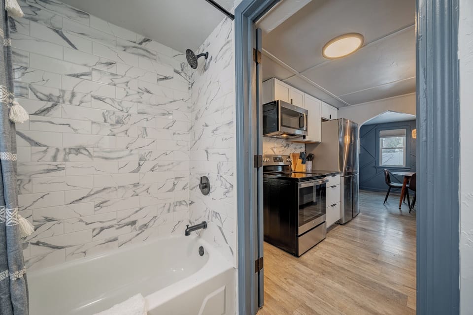 - Bright bathroom with modern tile shower and clean soaking tub for relaxing stays   - Steps away from the updated kitchen offering seamless easy guest access   - Fresh finishes create a welcoming space perfect for comfort and convenience