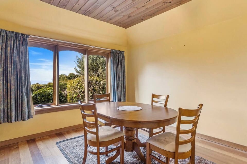 The dining area has a four-seater timber table and is conveniently located next to the kitchen. It overlooks the bay over serene treetops. 