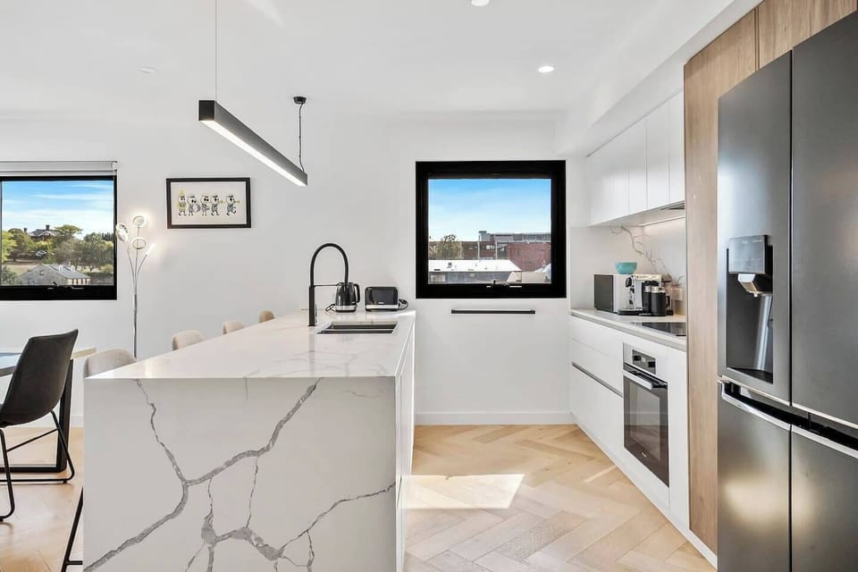 Cook effortlessly in the fully equipped modern kitchen with appliances and ample benchtop seating, perfect for both casual meals and gourmet cooking.