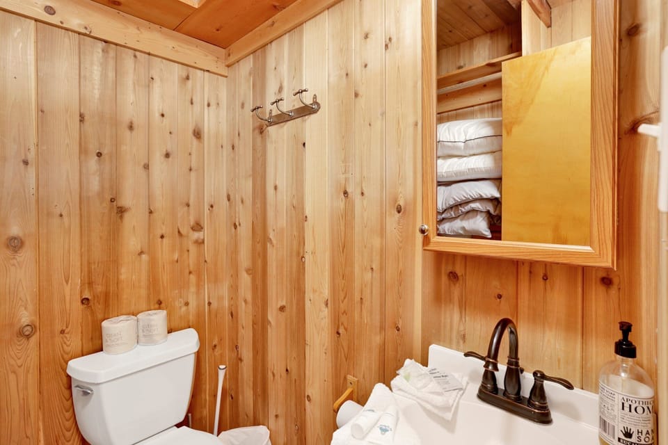 Clean and cozy cabin bathroom with a shower, sink, and toilet—simple, fresh, and comfortable for your everyday needs during a relaxing mountain stay.