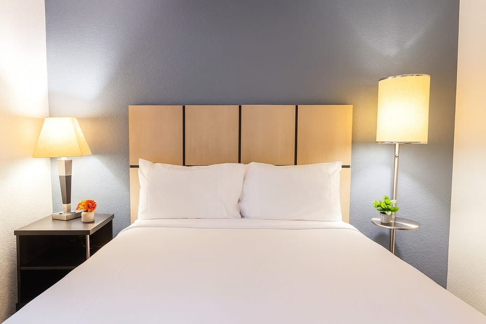 Sink into crisp linens beneath warm lamps for restful sleep.